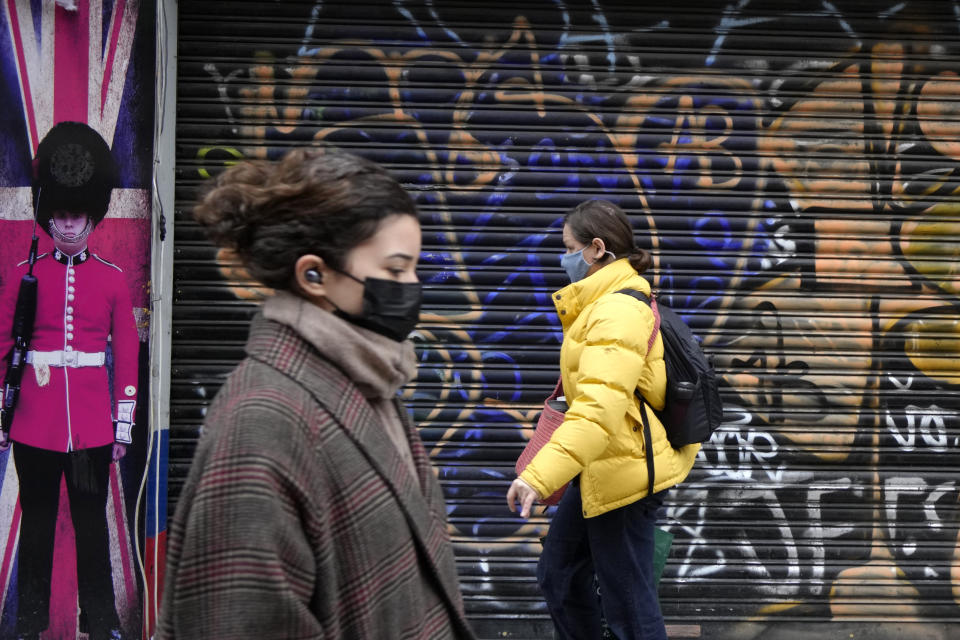 FILE - A shopper passes a closed shop on Oxford Street in London, Jan. 10, 2022. In the United Kingdom, mask-wearing in public places and COVID-19 passports will be dropped on Jan. 26, Prime Minister Boris Johnson announced Wednesday, Jan. 19, saying that the latest wave had “peaked nationally.” (AP Photo/Kirsty Wigglesworth, File)