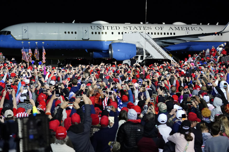 Supporters cheer as Air Force One with President Donald Trump arrives at at a campaign rally.