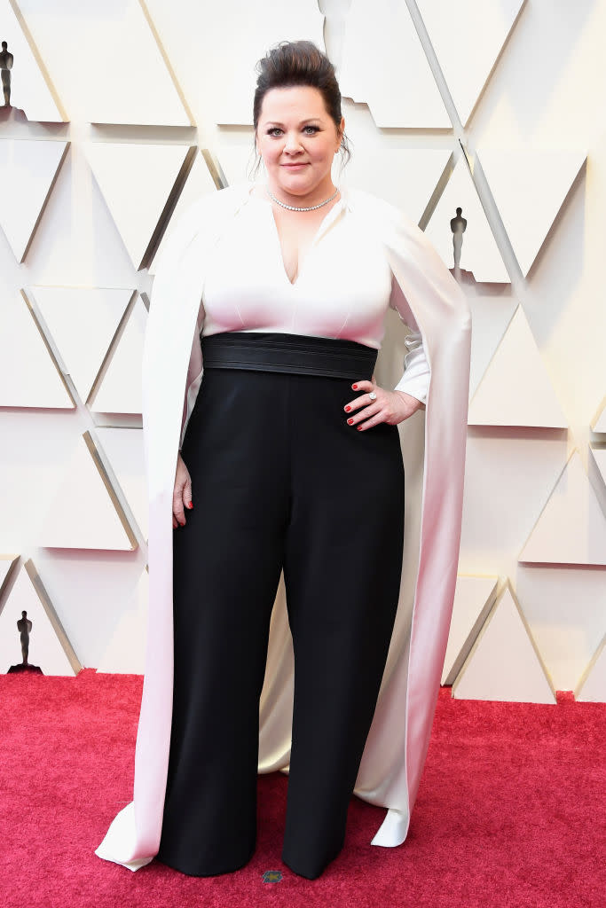 <p>Melissa McCarthy in her jumpsuit, nominated for her lead actress role in <i>Can You Ever Forgive Me?</i>, was better kitted out than those in gowns to make her way down the carpet. The black-and-white number was topped with an elegant white cape. (Photo: Getty Images) </p>