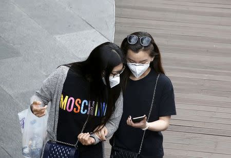 Women wearing masks to prevent contracting Middle East Respiratory Syndrome (MERS) look at a mobile phone at "N Seoul Tower" located atop Mt. Namsan in Seoul, South Korea, June 8, 2015. REUTERS/Kim Hong-Ji