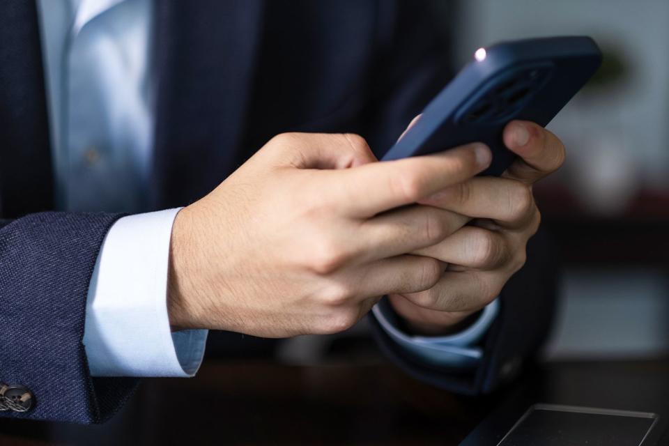 <p>uchar/Getty</p> Stock photo of hands texting 