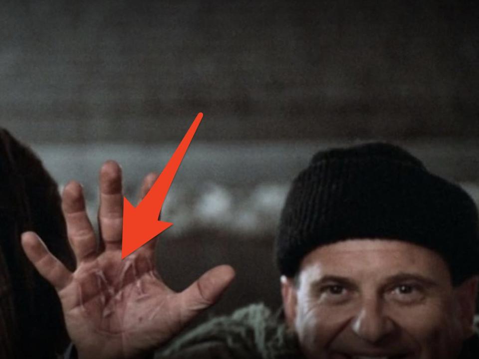 red arrow pointing to the M brand on harry's hand in home alone 2