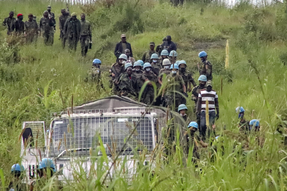 United Nations peacekeepers recover bodies from an area near the site where a U.N. convoy was attacked in Nyiragongo, North Kivu province, Congo, on Monday, Feb. 22, 2021. Luca Attanasio, Italian ambassador to the Congo, an Italian Carabineri bodyguard and a Congolese driver were killed in the area that is home to myriad rebel groups, according to the Foreign Ministry and local people. (AP Photo/Justin Kabumba)