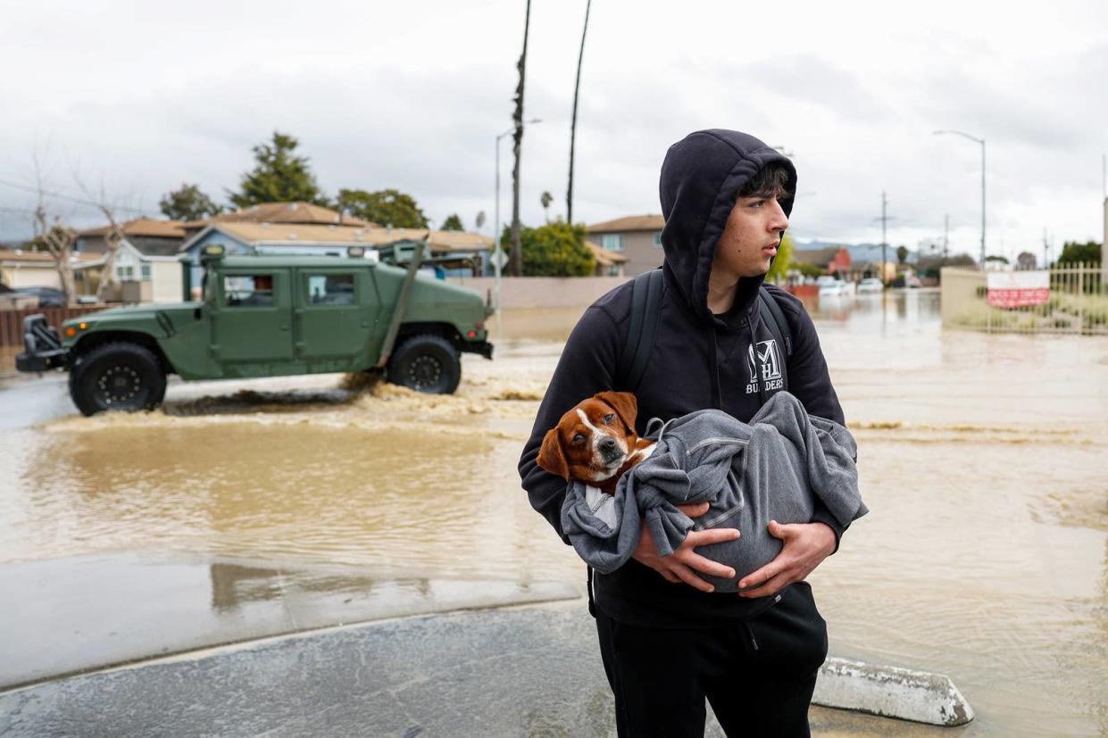 Esteban Sepulveda holds his dog Milo while leaving his home in Pajaro Valley, California, on March 12, 2023.