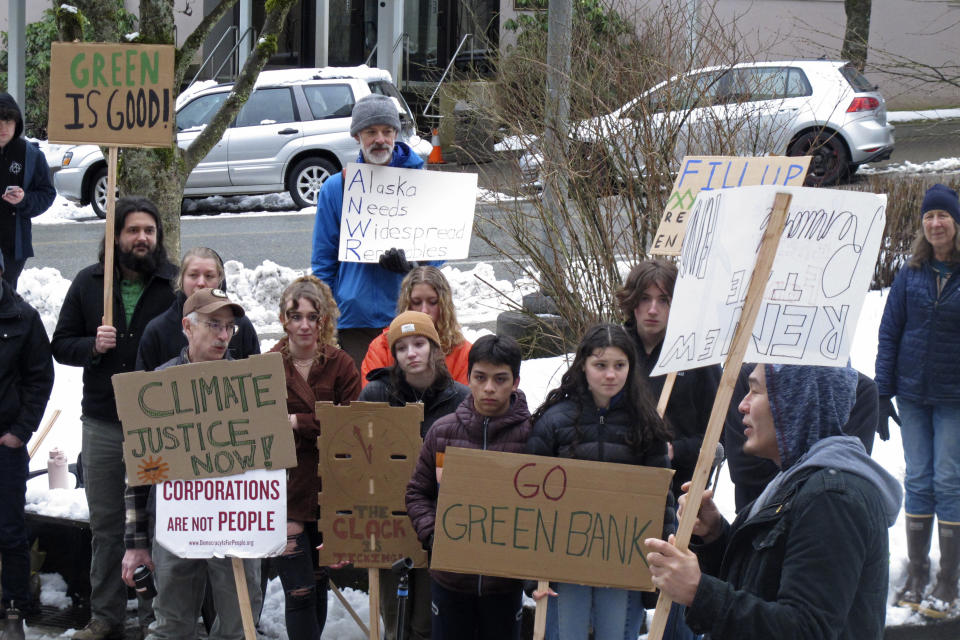 People rally in support of renewable energy policies, such as strengthening a renewable energy fund, across from the Alaska Capitol on Friday, Feb. 3, 2023, in Juneau, Alaska. Some environmentalists are skeptical of legislation proposed by Gov. Mike Dunleavy that aims to capitalize on carbon storage and carbon markets. (AP Photo/Becky Bohrer)