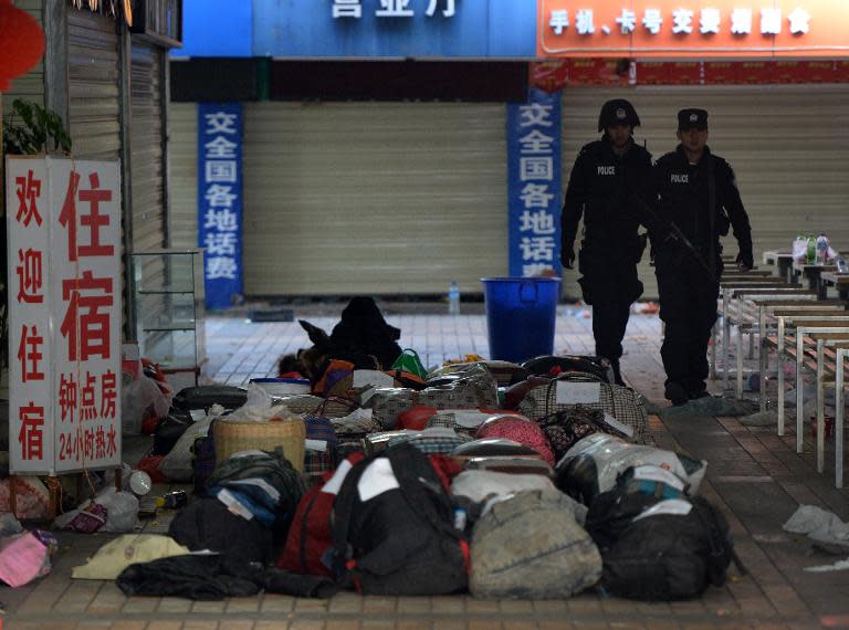 Police walk past abandoned luggage at the scene of a terror attack at the Kunming train station in Yunnan province on March 2, 2014