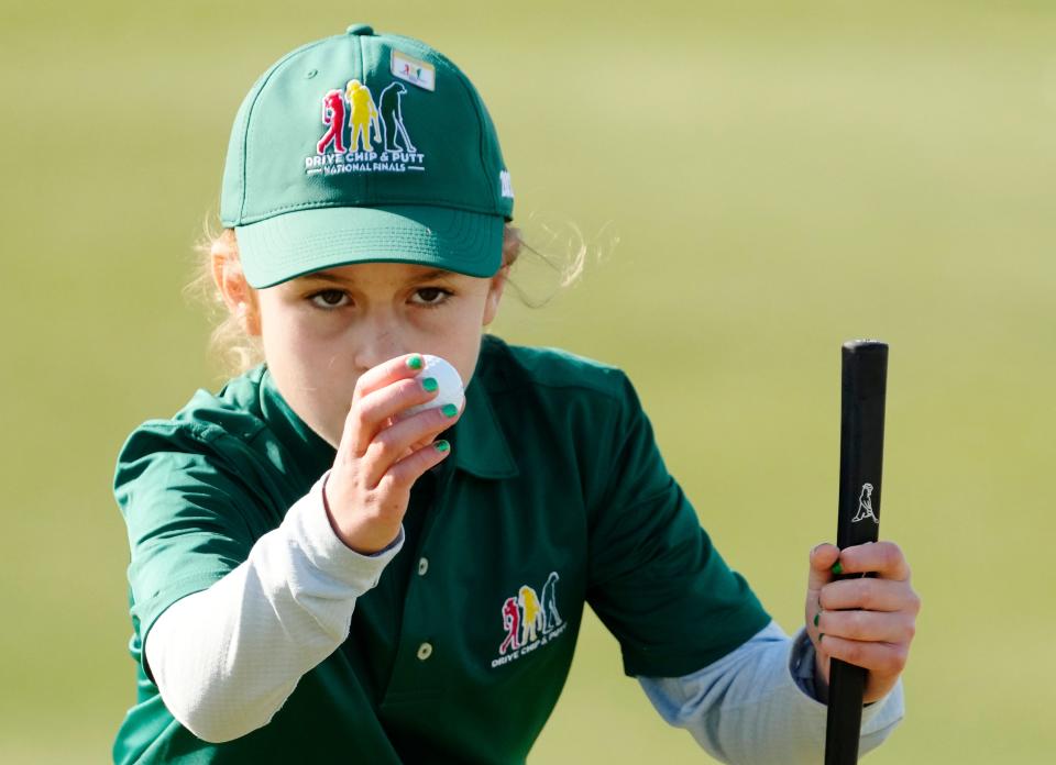 Isabelle Chandler from Ciornelius, N.C., lines up her putt on no. 18 during the Drive, Chip & Putt National Finals competition at Augusta National Golf Club.