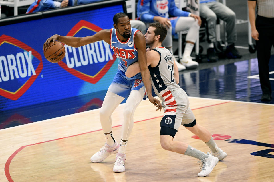 Brooklyn Nets forward Kevin Durant (7) dribbles as he is defended by Washington Wizards guard Garrison Mathews (24) during the first half of an NBA basketball game, Sunday, Jan. 31, 2021, in Washington. (AP Photo/Nick Wass)
