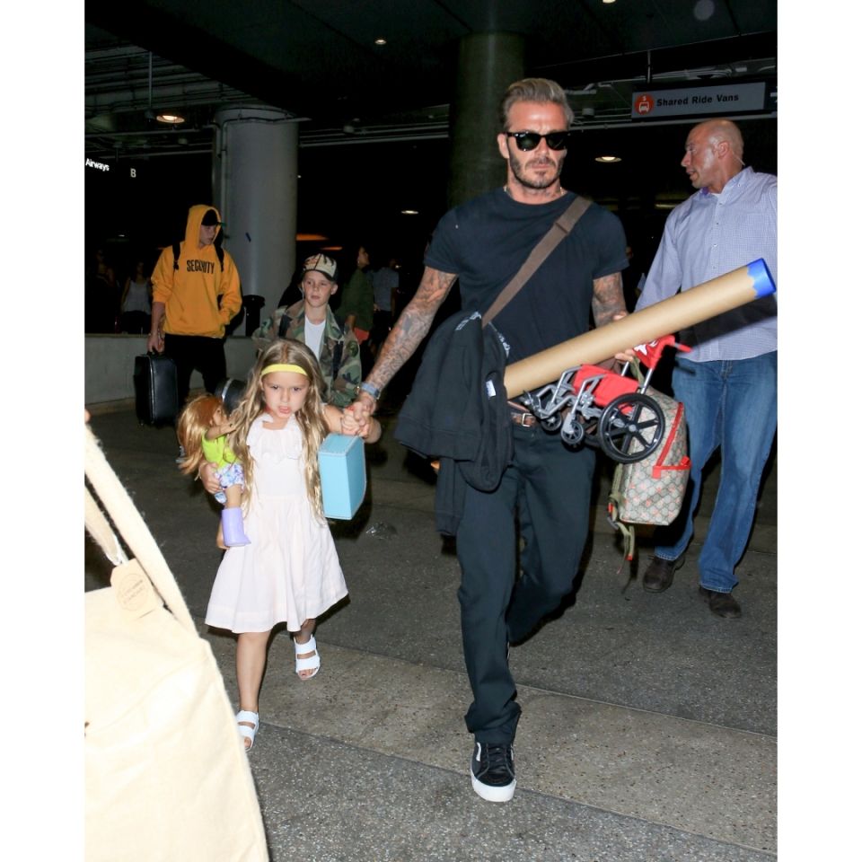 Harper lució adorable con su vestido blanco y sandalias en coordinación, mientras cargaba una muñeca.