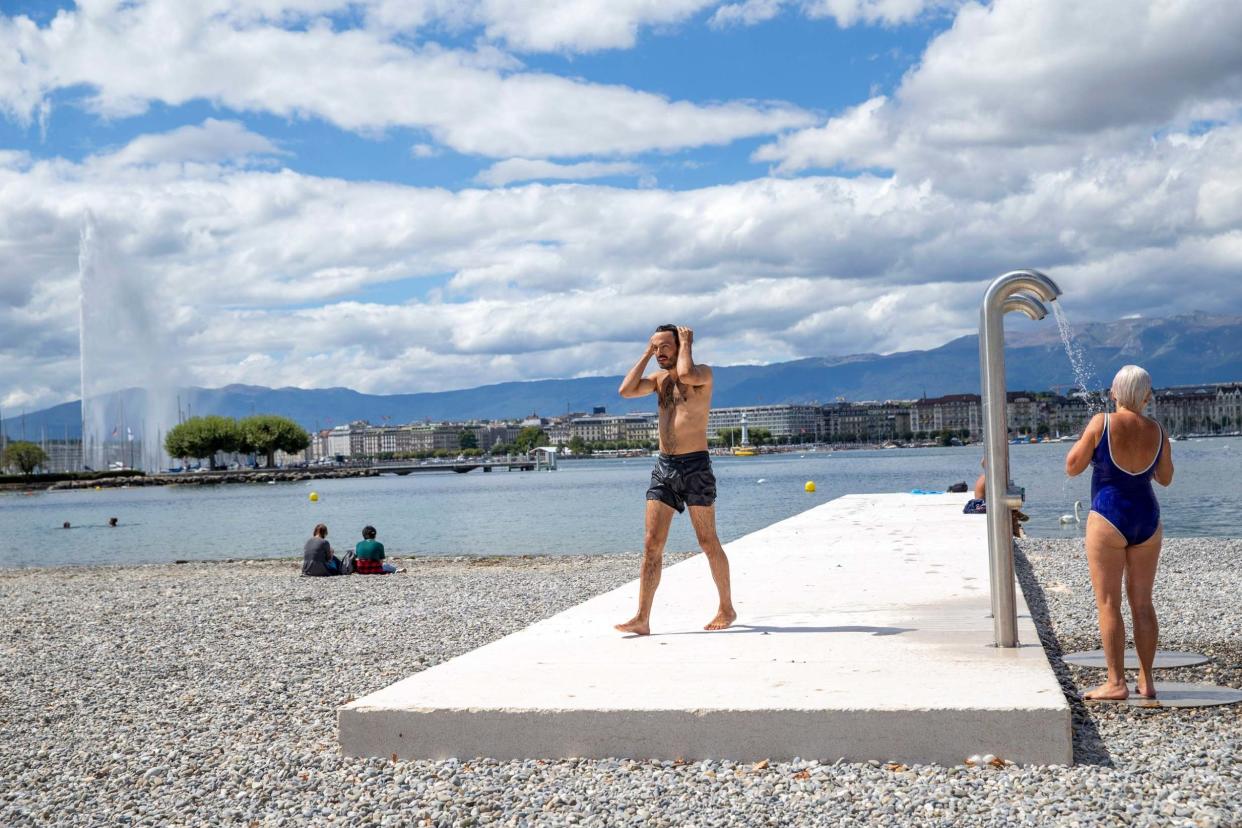People enjoy the reopening Plage des Eaux-Vives on the bank of the Geneva lake with the famous water fountain "Le Jet d'Eau": AP