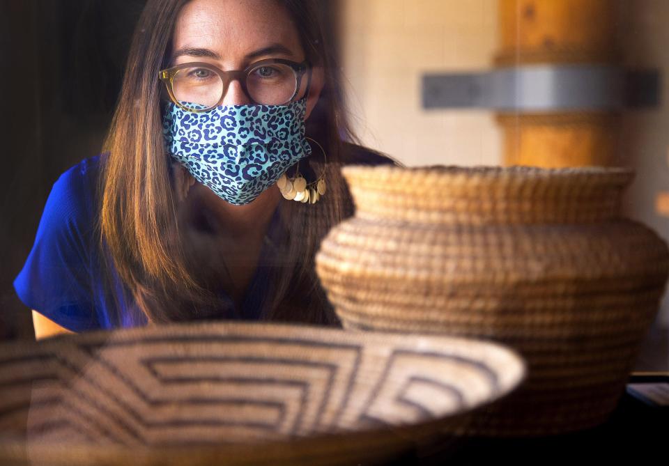 Emily Goble Early, curator of anthropology at Arizona Museum of Natural History, looks at some basketry plate and jar from the Akimel O'odham at the Mesa Grande Cultural Park. Arizona Museum of Natural History got a grant to research and document some items in their collection that may turn out to be funerary or ceremonial and need to be repatriated to a tribe.