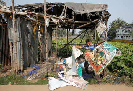 Rajiv Mondal, 36, a Trinamool Congress (TMC) party supporter shows a torn banner after his party office was burnt at Kanthi in Purba Medinipur district, February 6, 2019. REUTERS/Rupak De Chowdhuri/Files