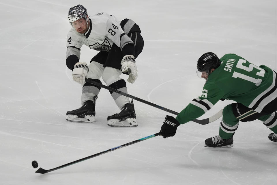 Dallas Stars center Craig Smith (15) and Los Angeles Kings defenseman Vladislav Gavrikov (84) skate for the puck during the first period an NHL hockey game in Dallas, Saturday, March 16, 2024. (AP Photo/LM Otero)