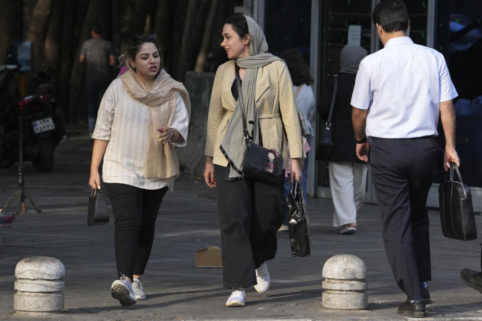 Iranian women walk in Tehran, Iran, Saturday, Aug. 5, 2023. These days, with uncovered women a common sight on Tehran streets, authorities have begun raiding companies where women employees or customers have been seen without the headscarf or hijab. Iran's parliament is discussing a law that would increase punishments on uncovered women and the businesses they frequent. (AP Photo/Vahid Salemi)