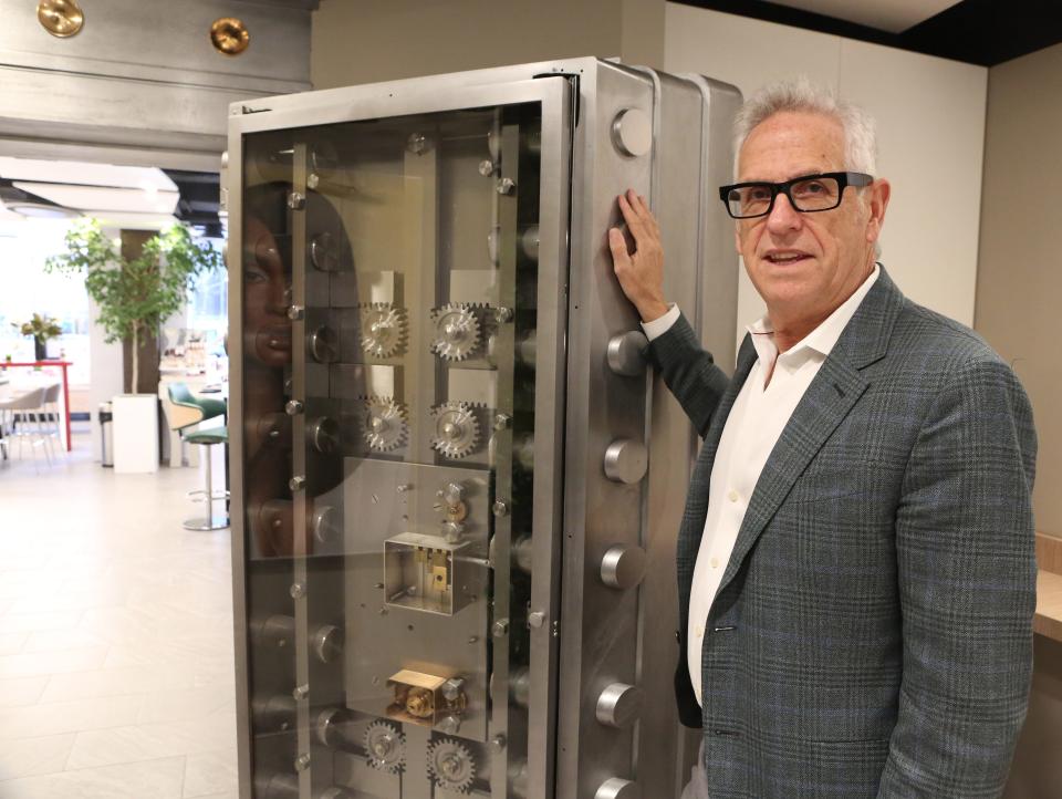 Randy Currie, owner of Currie Hair, Skin and Nails at the DuPont Building in Wilmington, stands next to a 10,000-pound vault door that was incorporated into the design of the business. The site used to be a bank.