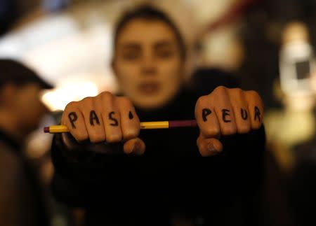 A woman is seen with "Not scared" written on her hands as she attends a vigil to pay tribute to the victims of a shooting by gunmen at the offices of weekly satirical magazine Charlie Hebdo in Paris at Republique square January 7, 2015. REUTERS/Youssef Boudlal