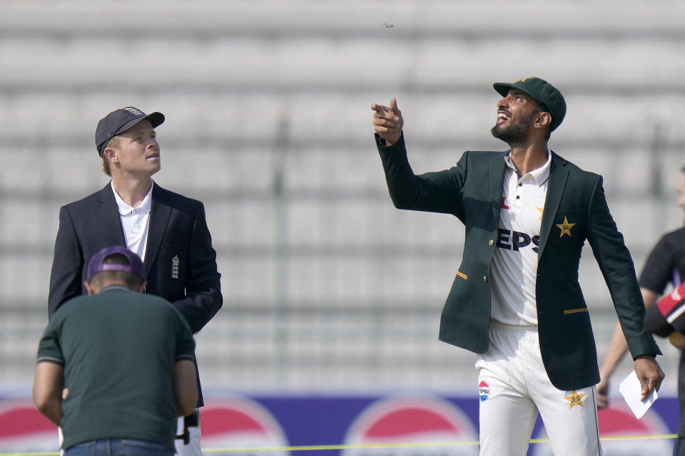 Pakistan's Shan Masood, right, flips the coin for toss as England's Ollie Pope, left, watches before the start of the play of first test cricket match between Pakistan and England, in Multan, Pakistan, Monday, Oct. 7, 2024. (AP Photo/Anjum Naveed)