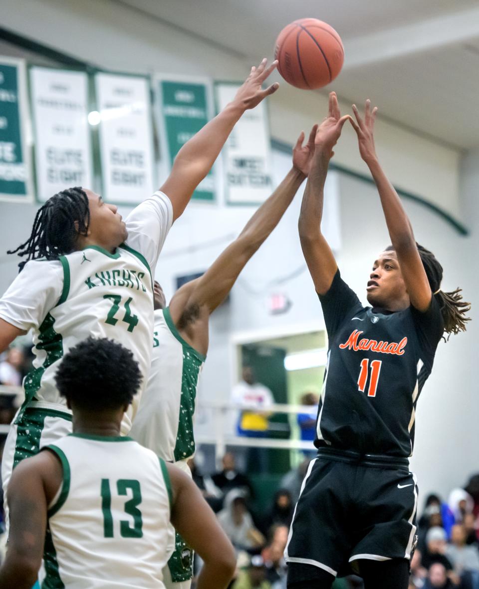 Manual's Dietrich Richardson (11) puts up a shot over Richwoods' Lathan Sommerville in the first half of their Big Twelve Conference basketball game Tuesday, Dec. 5, 2023 at Richwoods High School. The Knights defeated the Rams 73-51.