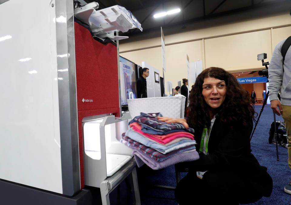 Debbie Cohen-Abravanel, CMO at FoldiMate, takes folded laundry from a FoldiMate automatic laundry folding machine, during CES Unveiled at the 2018 CES in Las Vegas, Nevada, U.S. January 7, 2018. REUTERS/Steve Marcus