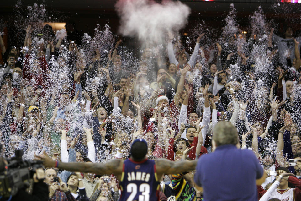 FILE - In this Dec. 25, 2008, file photo, fans toss confetti to mimic Cleveland Cavaliers' LeBron James's pre-game chalk toss before an NBA basketball game against the Washington Wizards in Cleveland. Addressing airborne threats like the novel coronavirus is a particular challenge, especially when they can stick around for hours wherever they might land. (AP Photo/Mark Duncan, File)