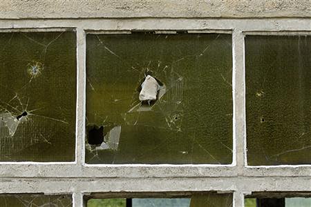 A stone is seen wedged in a window at a derelict coal mine in Aninoasa, 330 km (202 miles) west of Bucharest July 30, 2013. REUTERS/Bogdan Cristel