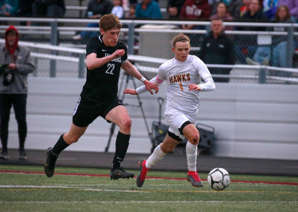Ankeny senior Lucas Newhard advances the ball up the field as Ankeny Centennial senior Quinn Geiger chases after during the Pack the Pitch soccer game on Tuesday, May 3, 2022, in Ankeny.