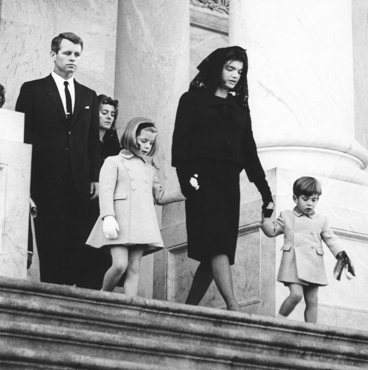 Members of the Kennedy family leave the US Capitol follwing a brief service, leaving the body of assassinated President John F. Kennedy where it will lie in state, Washington DC, November 24, 1963. Visible are Jacqueline Kennedy (1929 - 1994) (center), her children, John Kennedy Jr (1960 - 1999) (right) and Caroline Kennedy, and her brother-in-law Ted Kennedy