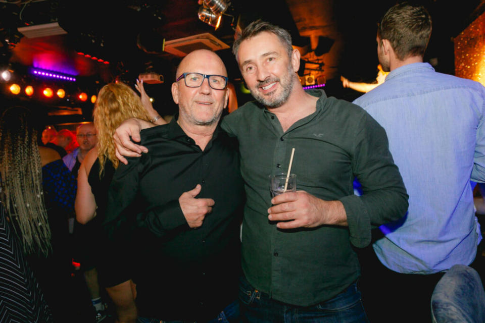 Two smiling men in a nightclub