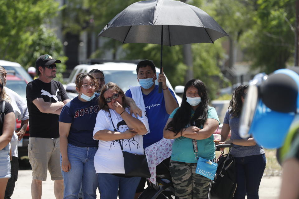 Mourners gather as they shed tears during a news conference announcing the opening of Adam's Place Inc., a not-for profit organization aiming to help at-risk youth from Chicago and other Midwestern cities to remain out of trouble, Wednesday, May 26, 2021 in Chicago's West Side. Adam Toledo, 13, was shot and killed March 29 by a Chicago police officer. (AP Photo/Shafkat Anowar)