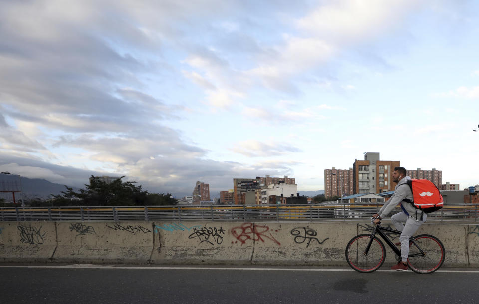 Venezuelan bicycle courier Samuel Romero pedals through Bogota, Colombia, at the start of his work day on Wednesday, July 17, 2019. Romero said that when he joined Rappi in February, he was making almost $22 each day but that his average daily amount had now dropped to about $15. (AP Photo/Fernando Vergara)