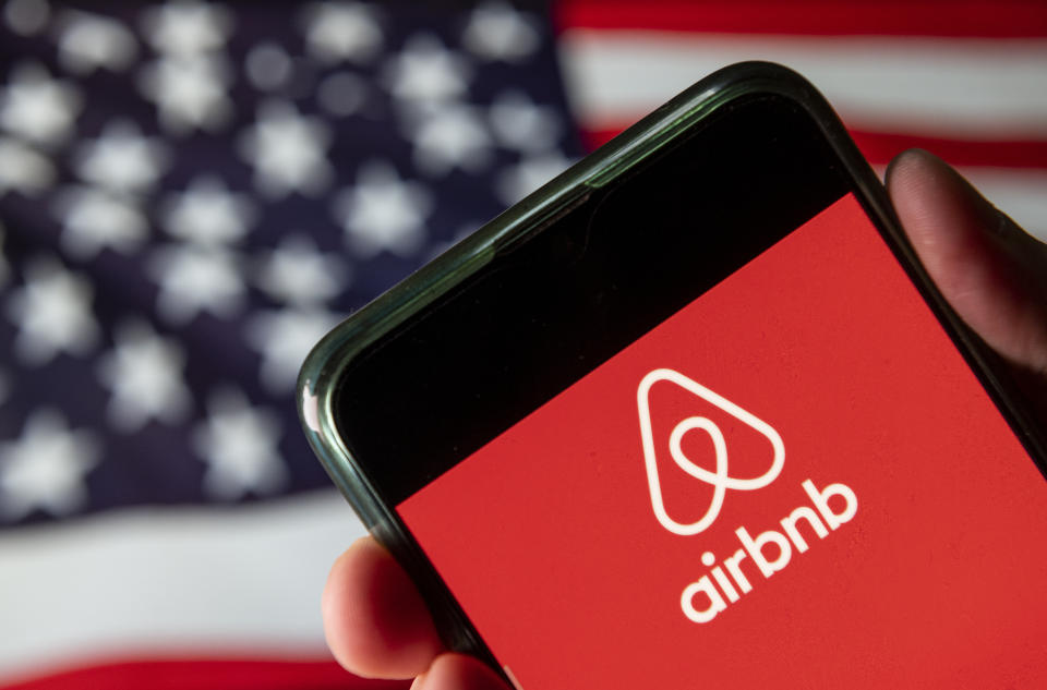 CHINA - 2020/08/15: In this photo illustration the American online marketplace and hospitality service Airbnb logo is seen on an Android mobile device with United States of America flag in the background. (Photo Illustration by Budrul Chukrut/SOPA Images/LightRocket via Getty Images)