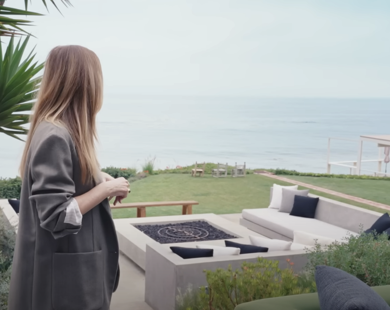 ellen looking at firepit area with large gas firepit and sofas surrounding