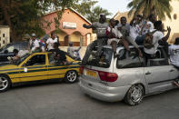 Supporters of the Gambian President Adama Barrow celebrate the partial results that give the lead to their candidate during the counting ballots in Gambia's presidential election, in Banjul, Gambia, Sunday, Dec. 5, 2021. Election officials in the West African nation of Gambia have started counting marble votes after polls closed for the first presidential election in decades that does not include former dictator Yahya Jammeh as a candidate. (AP Photo/Leo Correa)