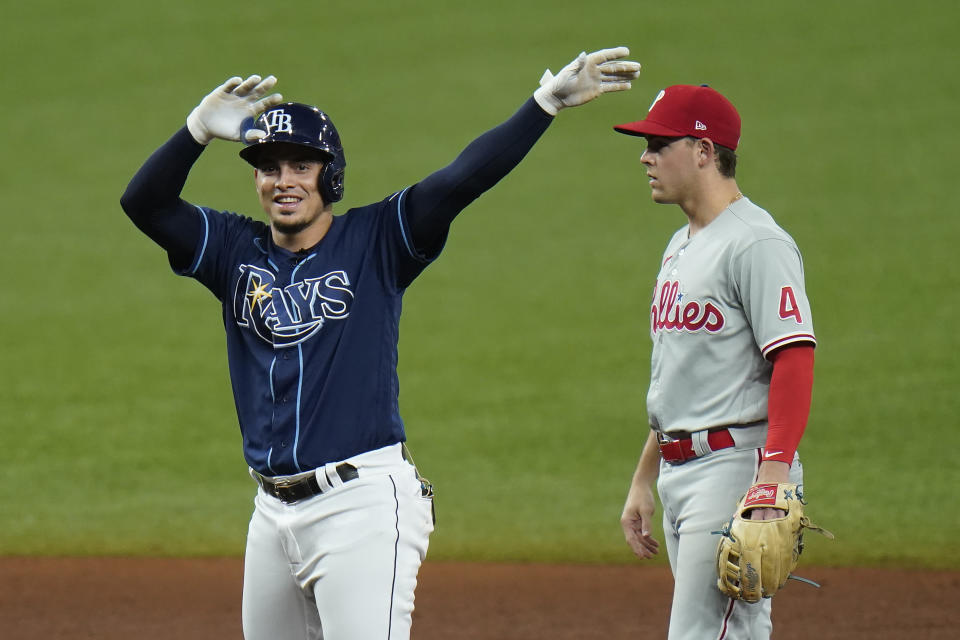 Tampa Bay Rays' Willy Adames celebrates after hitting an RBI double off Philadelphia Phillies starting pitcher Zack Wheeler during the fifth inning of a baseball game Saturday, Sept. 26, 2020, in St. Petersburg, Fla. Looking on is Phillies' Scott Kingery (4). (AP Photo/Chris O'Meara)