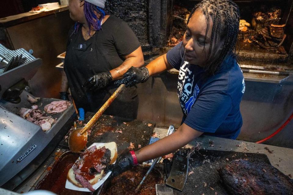 Tausha Hammett, owner of LC’s Bar-B-Q and granddaughter of founder L.C. Richardson, sauces up a burnt end sandwich.