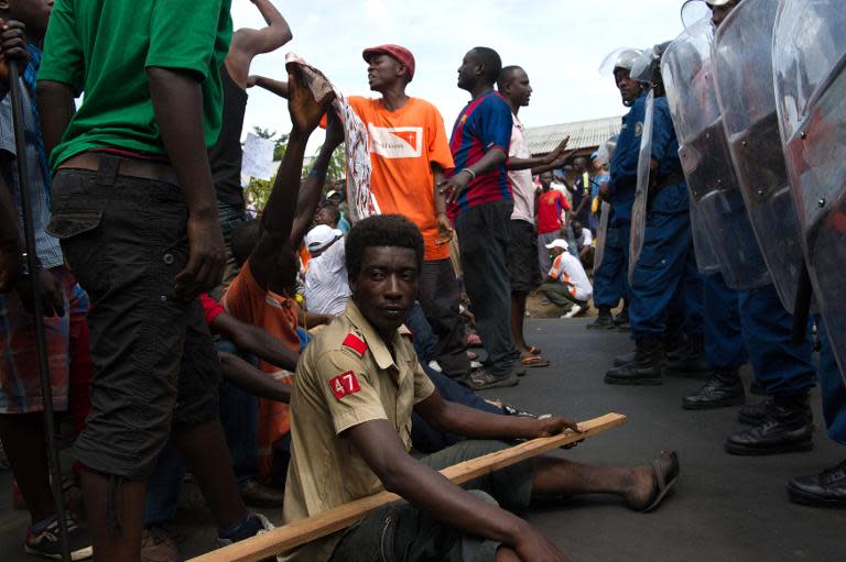 A protestor sits on the ground in front of police lines in the Musaga neighbourhood of Bujumbura, on May 4, 2015