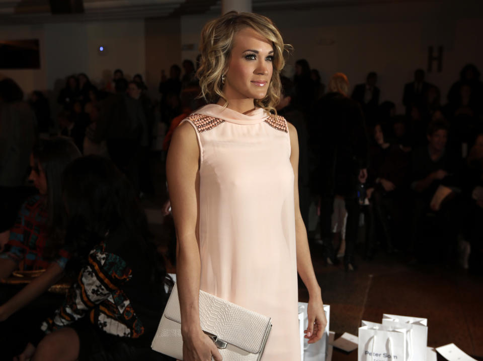 Singer Carrie Underwood poses for photos before the Peter Som Fall 2014 collection is modeled during Fashion Week in New York, Friday, Feb. 7, 2014. (AP Photo/Richard Drew)