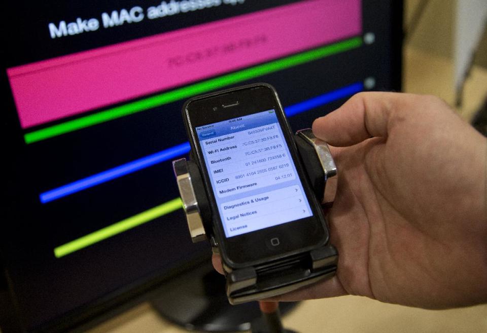 Technologist Seth Schoen holds a cell phone as it displays information, also seen on the screen behind, during a Federal Trade Commission (FTC) mobile tracking demonstration, Wednesday, Feb. 19, 2014, in Washington. You might want to keep your cellphone home _ or at least turn it off _ when you go shopping. Stores are using technology to track consumers’ movements, but they say the information is anonymous. The Federal Trade Commission takes a look at the information these companies are collecting, how long they are keeping it and what it’s being used for. (AP Photo/Carolyn Kaster)