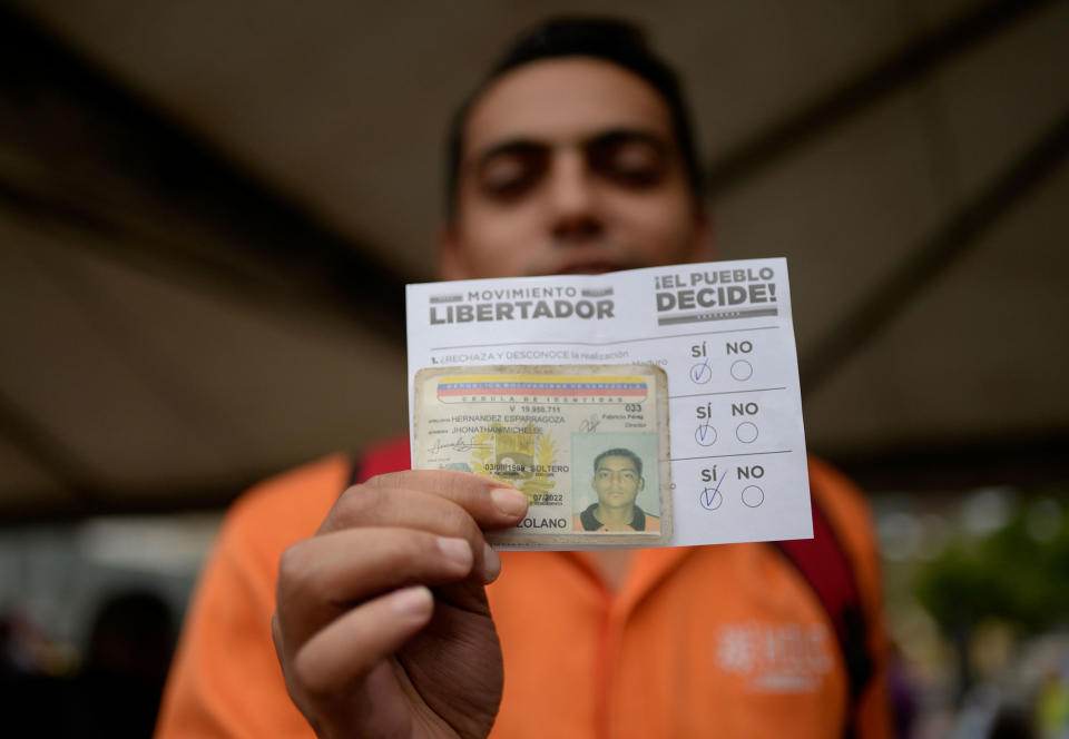 <p>A man shows his ID card and ballot at a polling station in Caracas on July 16, 2017 during an opposition-organized vote to measure public support for Venezuelan President Nicolas Maduro’s plan to rewrite the constitution.<br> Authorities have refused to greenlight the vote that has been presented as an act of civil disobedience and supporters of Maduro are boycotting it. Protests against Maduro since April 1 have brought thousands to the streets demanding elections, but has also left 95 people dead, according to an official toll. (Federico Parra/AFP/Getty Images) </p>