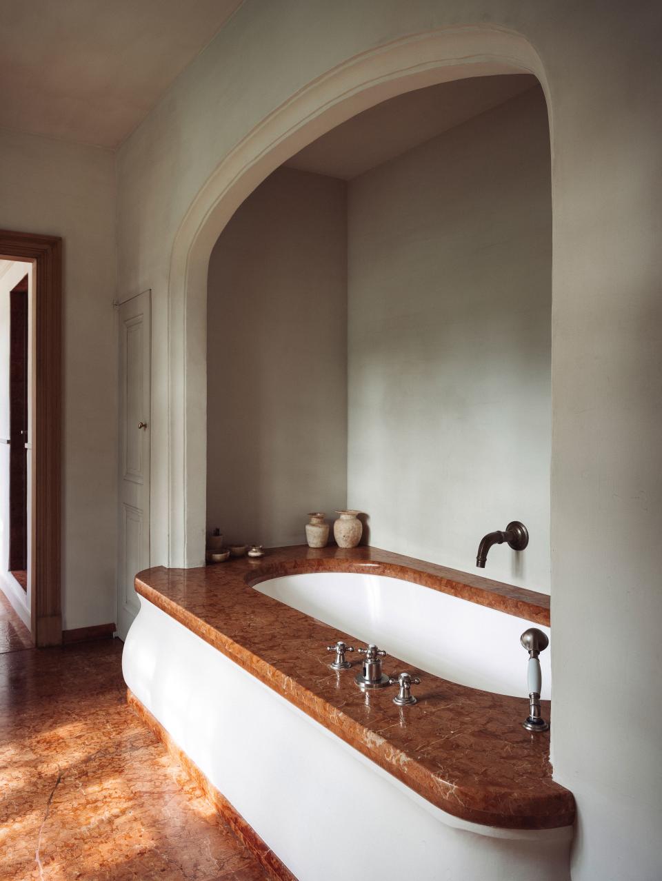 A recessed tub in the master bath overlooks garden greenery.