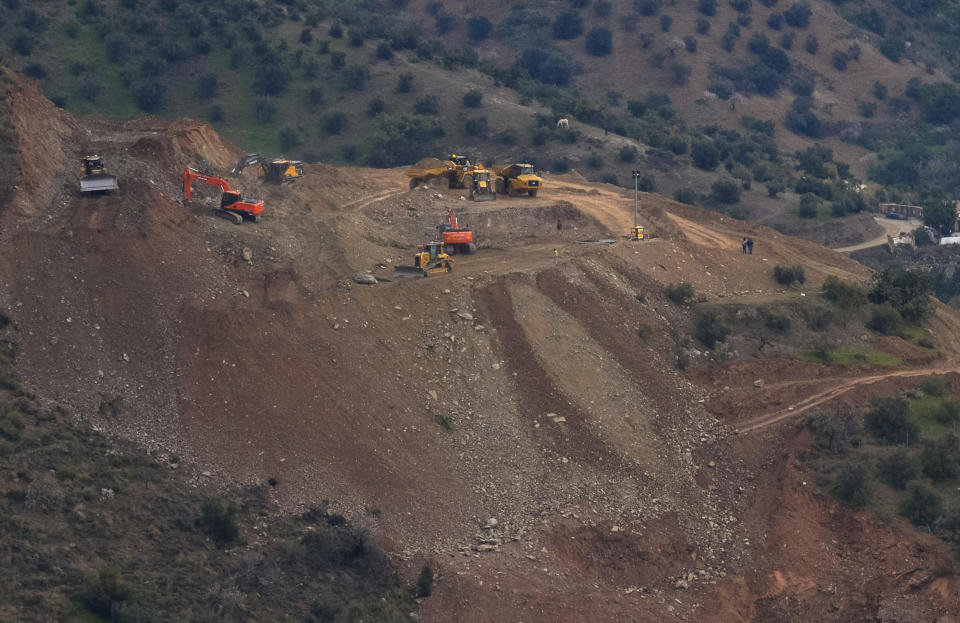 Drill machines and excavating machinery work on top of the mountain, next to a deep borehole to reach a 2-year-old boy trapped there for six days near the town of Totalan in Malaga, Spain, Saturday, Jan. 19, 2019. Authorities in southern Spain say that they hope to reach the spot where they believe the two-year-old boy who fell in a borehole six days ago is trapped in approximately 35 hours. The leading engineer coordinating the search-and-rescue operation says Saturday that the estimate depends on everything "going favorably." (AP Photo/Gregorio Marrero)