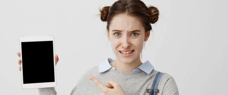 Closeup picture of woman with upset emotions gesturing with index finger on modern device in hand.