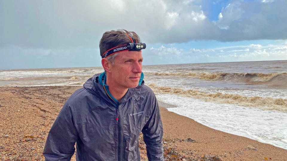 Man wearing AceBeam H50 2.0 Headlamp on beach