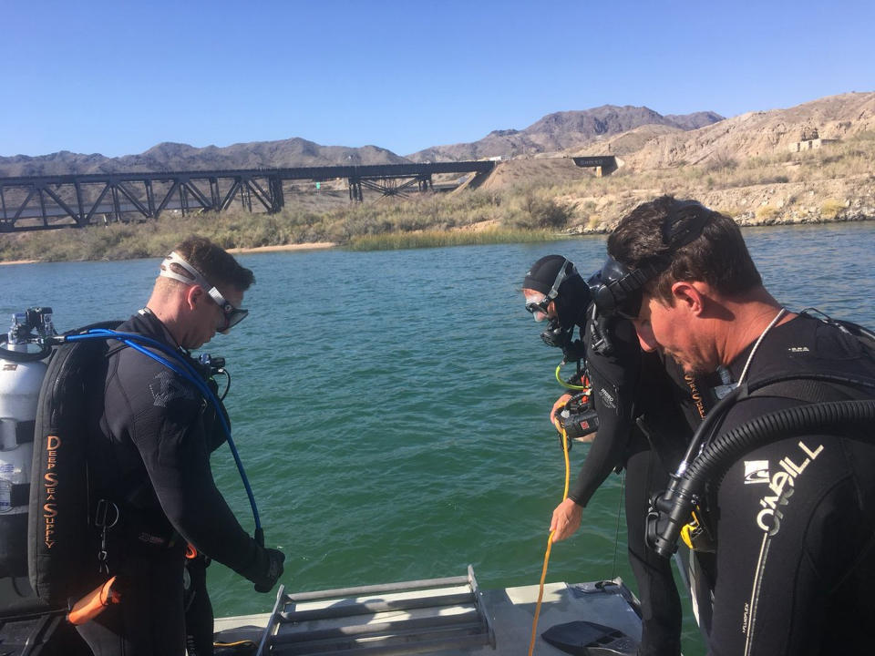 In this photo released by Los Angeles Sheriff Department Special Enforcement Bureau their dive team assists San Bernardino County Sheriffs in the search for three missing persons in the Colorado river Monday, Sept. 3, 2018, north of Lake Havasu, near Topock, Ariz. The body of a California woman who was among four people missing after two boats collided on the river was found Monday, authorities said. Christine Lewis, 51, of Visalia, Calif., was discovered in a section of the river along the California-Arizona border, Mohave County Sheriff's Office spokeswoman Anita Mortensen said. (Los Angeles Sheriff Department Special Enforcement Bureau via AP)