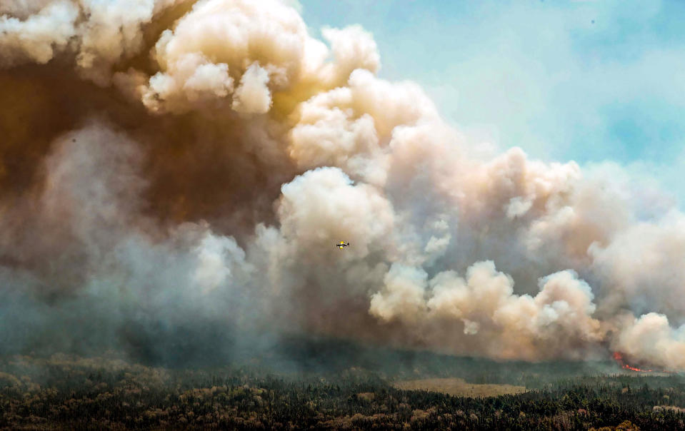 Image: One of eight aircrafts from New Brunswick that drops a mix of water and fire retardant makes a pass over the fire near Barrington Lake, Shelburne County, Nova Scotia province on May 31, 2023. (Nova Scotia Government via AFP - Getty Images)