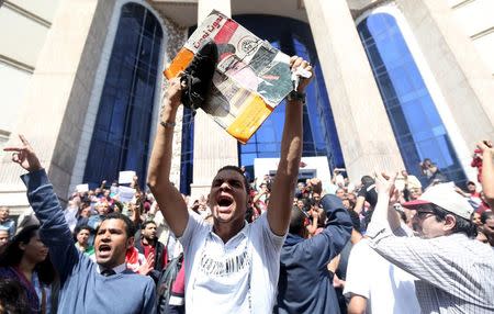 An Egyptian activist hits a poster of President Abdel Fattah al-Sisi with a shoe during a demonstration protesting the government's decision to transfer two Red Sea islands to Saudi Arabia, in front of the Press Syndicate in Cairo, Egypt, April 15, 2016. REUTERS/Mohamed Abd El Ghany