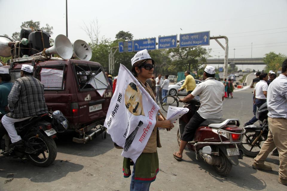 A woman supporter carries a flag with a portrait of Aam Aadmi Party (AAP), or common man party, chief Arvind Kejriwal during an election campaign rally in New Delhi, India, Wednesday, April, 2, 2014. The election commission says 363 political parties participated in the 2009 elections. The number will likely be similar in this election that will be held from April 7 to May 12, although only seven of these are nationally recognized parties and another 34 were recognized as regional parties. (AP Photo/Tsering Topgyal)