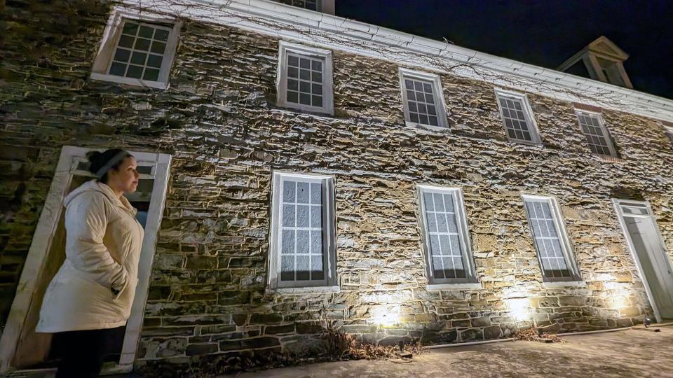 Madison Crouthamel, a teacher at Spring Grove Area Middle School who attended a borough meeting Thursday evening, stands in front of the Hoke House in Spring Grove. The electricity to illuminate the building is scheduled to be turned off.