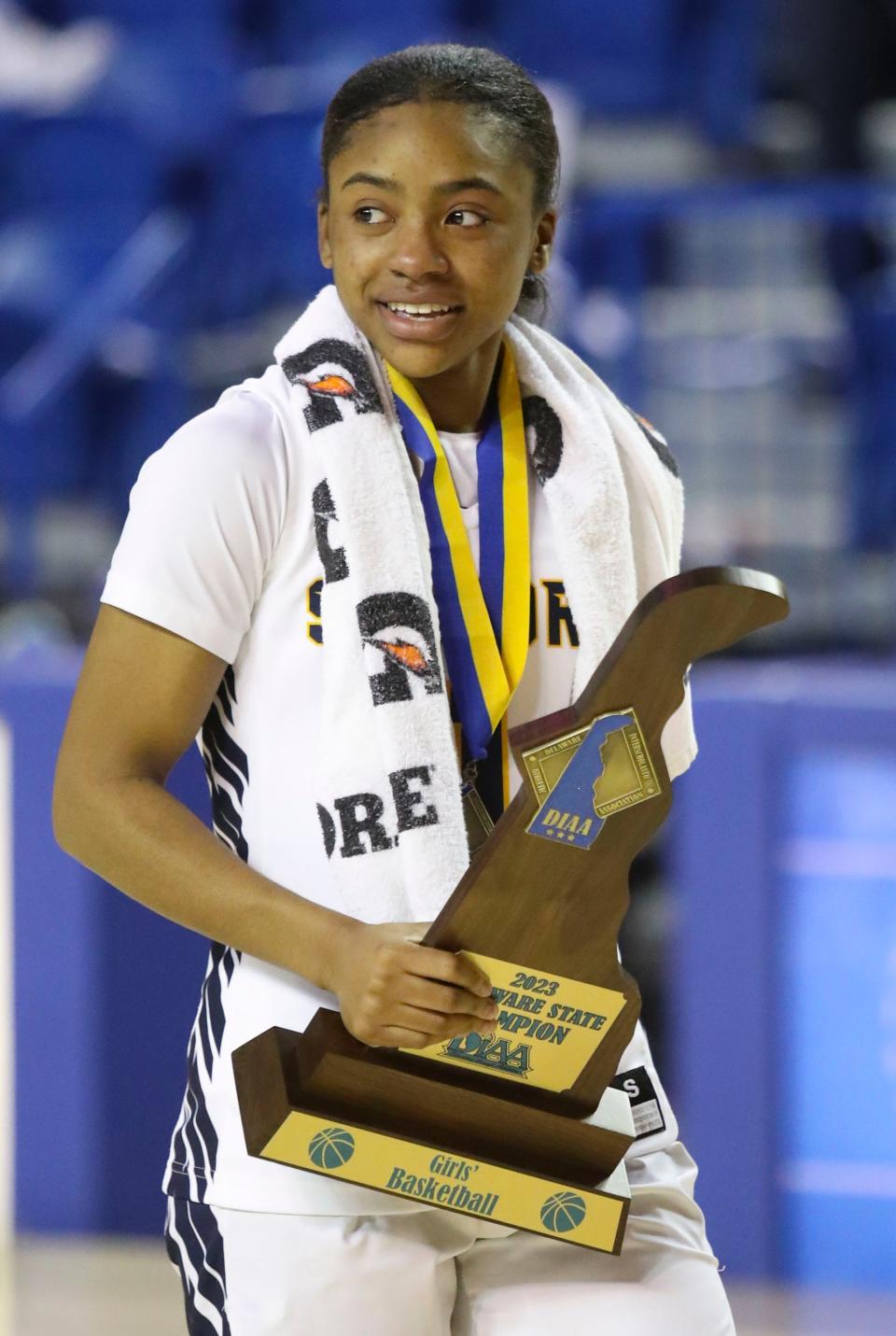 Sanford's Zy Kilgoe carries the championship trophy in the second half of the Warriors' 58-46 win in the DIAA state tournament championship game at the Bob Carpenter Center, Friday, March 10, 2023.