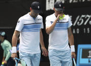 Mike Bryan, left, of the U.S. talks with his brother Bob during their third round doubles match against Croatia's Ivan Dodig and Slovakia's Filip Polasek at the Australian Open tennis championship in Melbourne, Australia, Monday, Jan. 27, 2020. (AP Photo/Dita Alangkara)